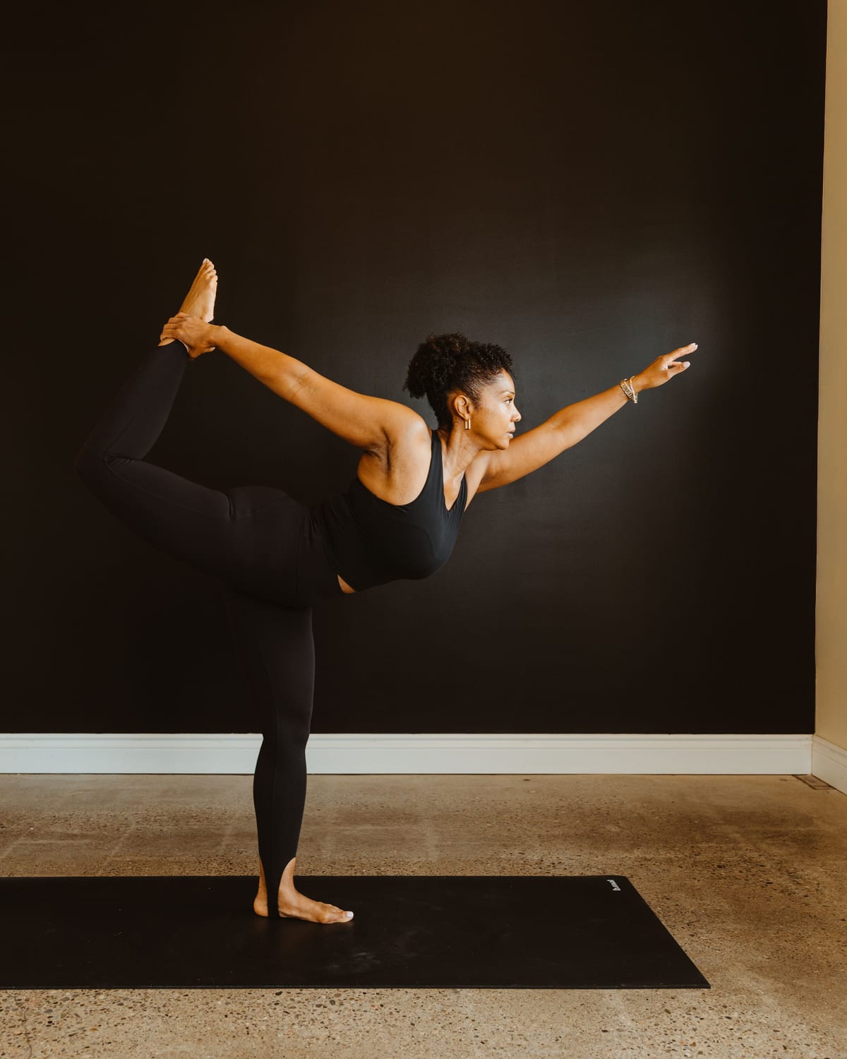 A teacher in dancer's pose against the studio wall