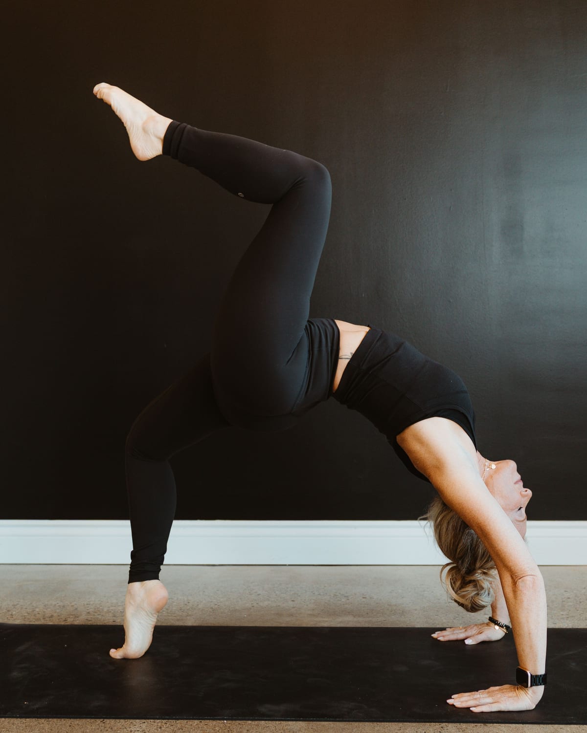 A teacher in wild thing, a backbend on one hand with a leg raised