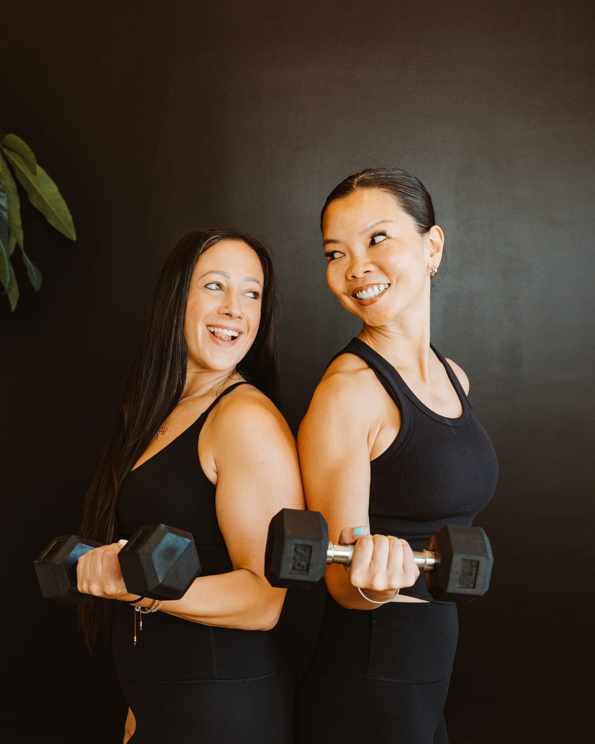 Two members training together with dumbbells